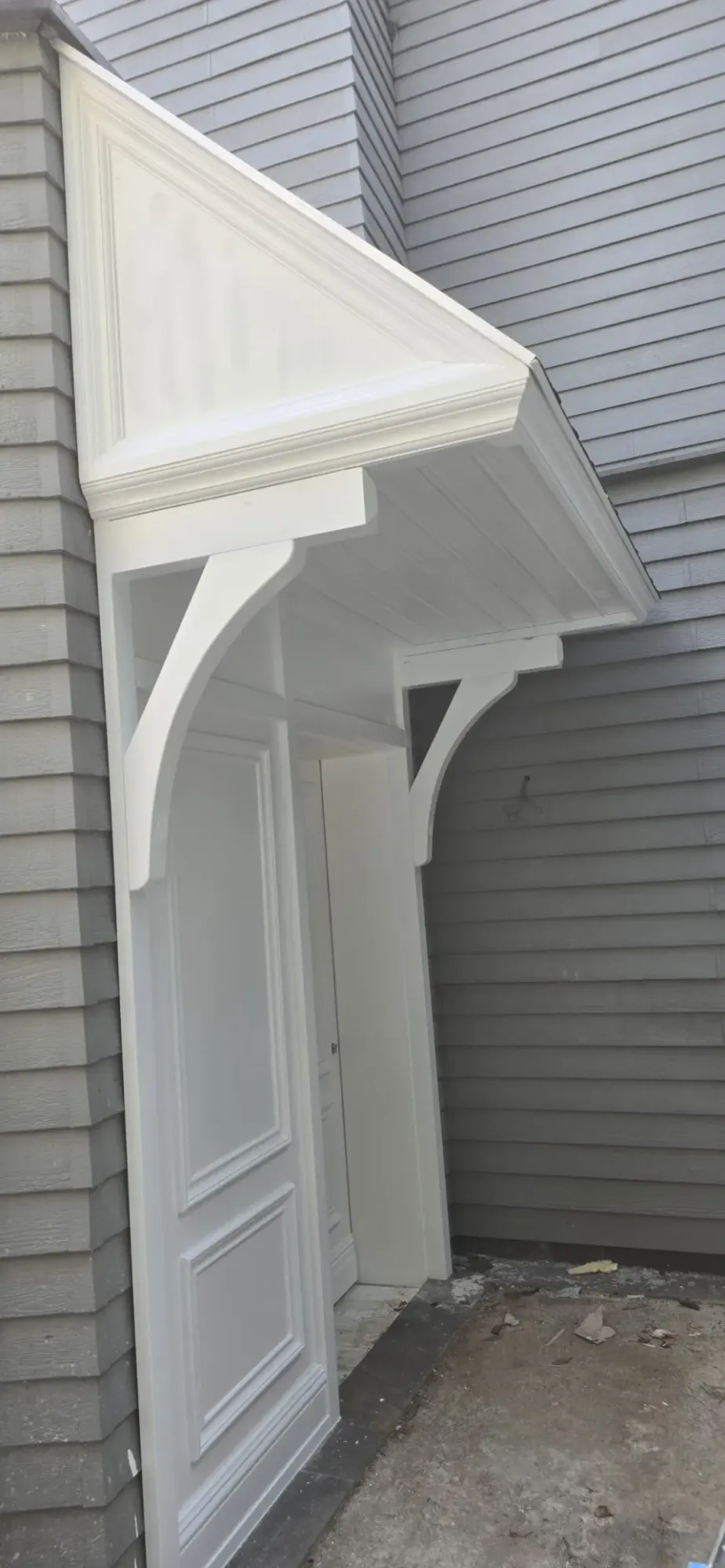 Side profile of the white entry canopy with curved support brackets