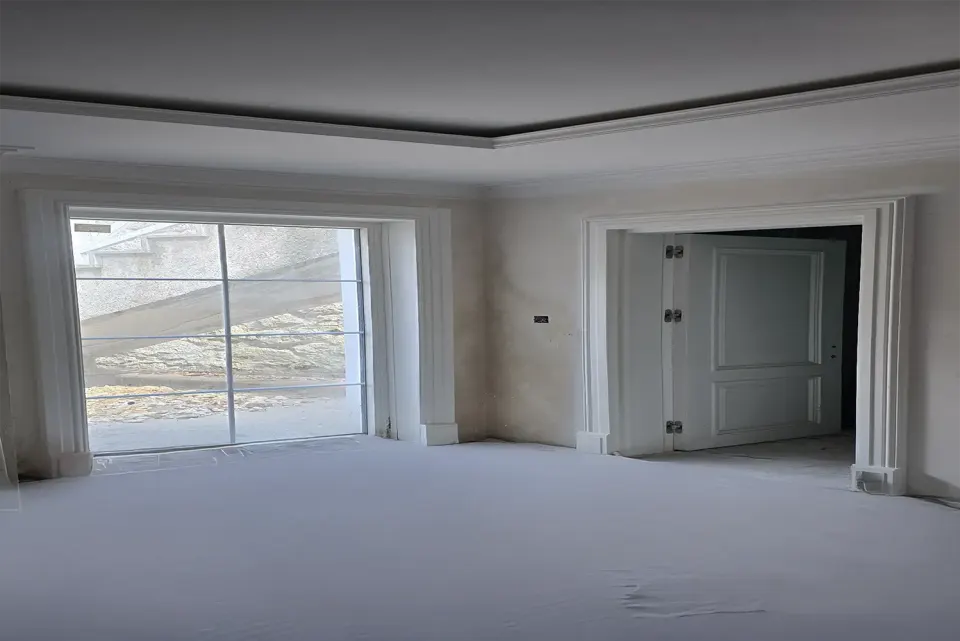 Room with a wide white window casing and a panelled double door