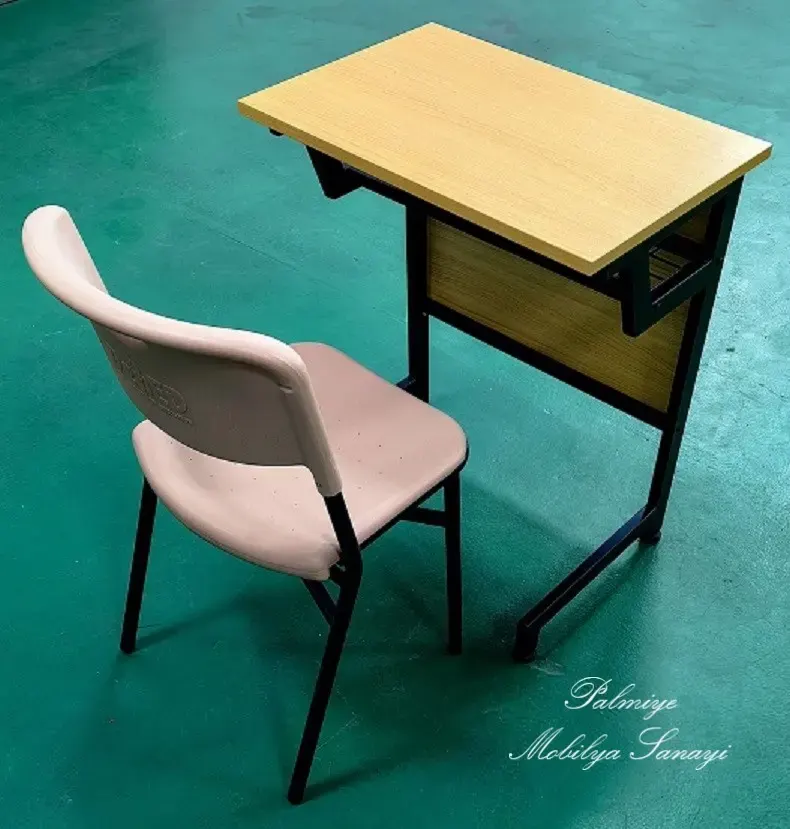 Single school desk with light wood-tone top paired with a beige plastic chair