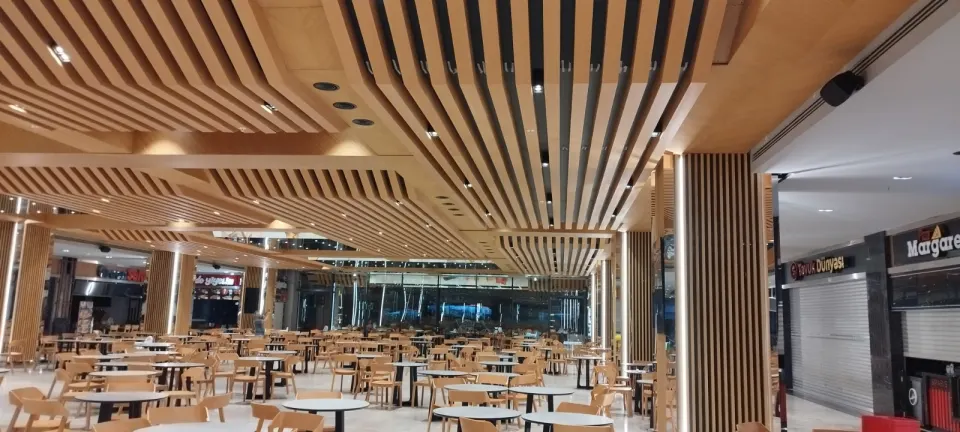Long run of wooden ceiling slats with a slatted column by closed food court shops