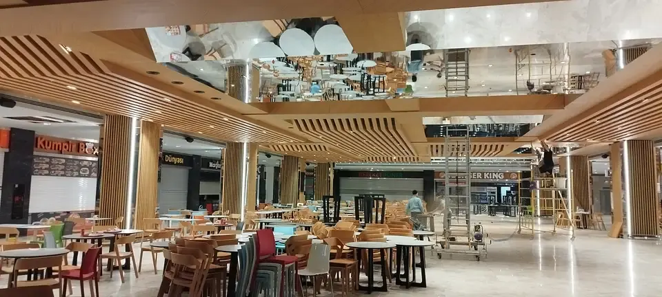 Wooden slatted ceiling and mirror panels in a dining hall, echoing hotel lobby style wood fit-outs
