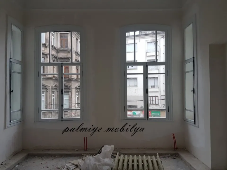 Arched white windows during the historic building refit with a radiator below