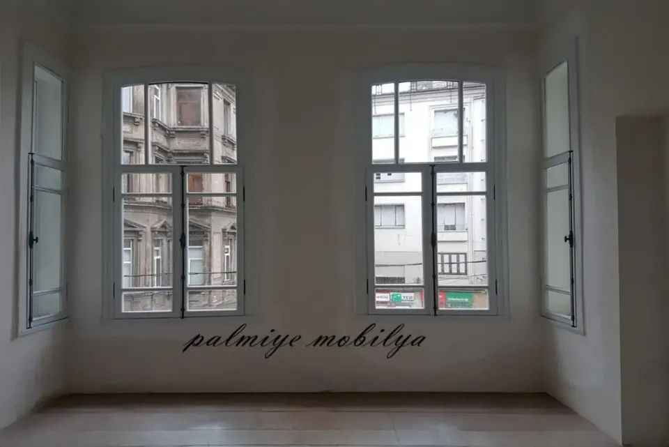 Arched white timber windows in a renovated room of a historic building