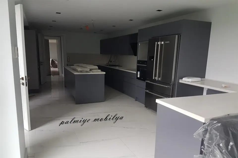 Anthracite kitchen with a white-topped island and built-in fridge