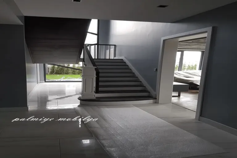 Villa hallway with a dark-treaded white staircase and wide white door casing during the home refit